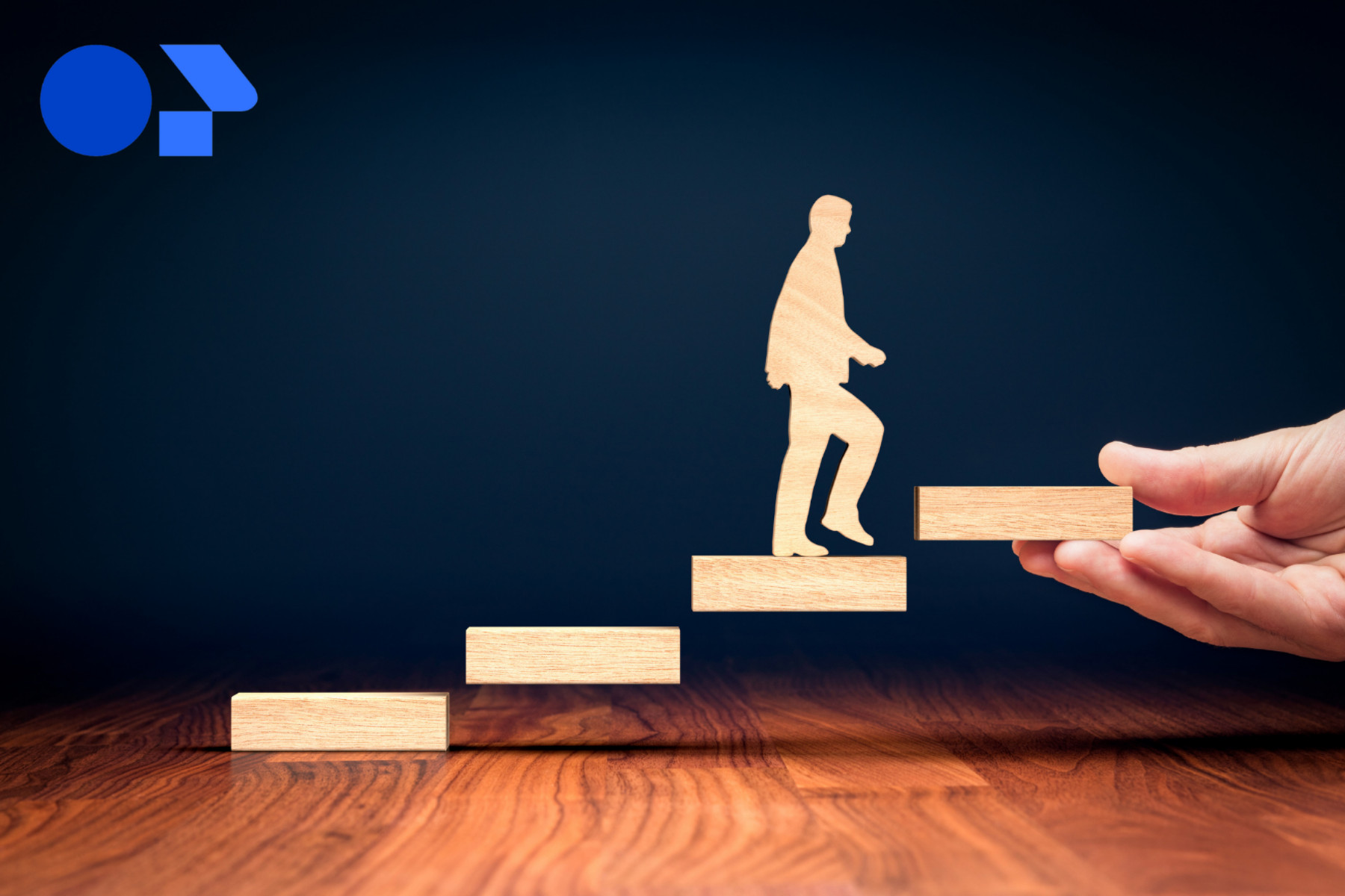 hand holding wooden figure representing man walking up steps. Meant to provoke the connection of personal progress with coaching.